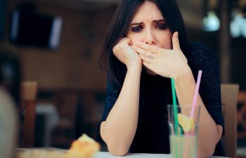 nauseated woman at the restaurant table